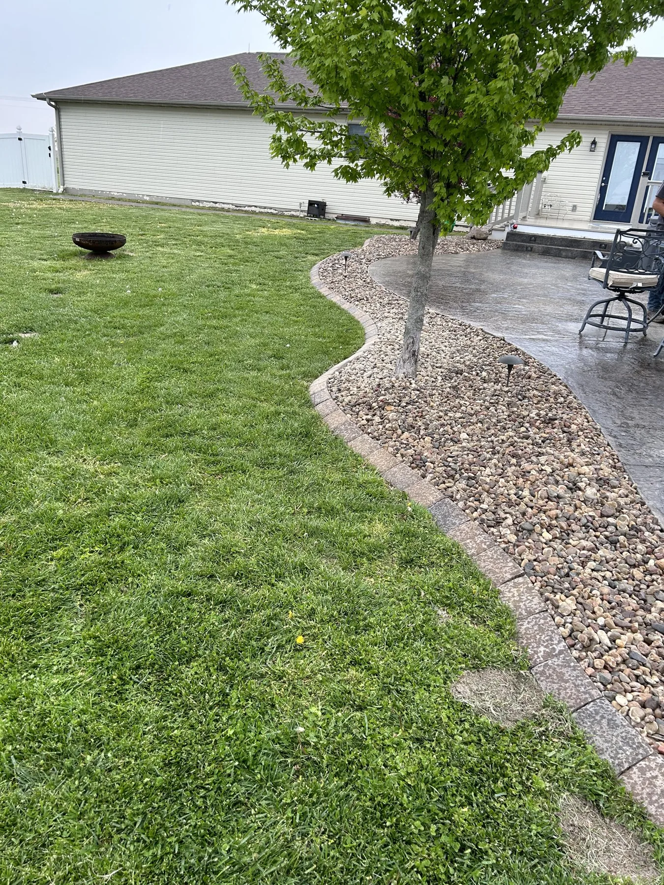 Manicured lawn with a paver path and mulched planting beds