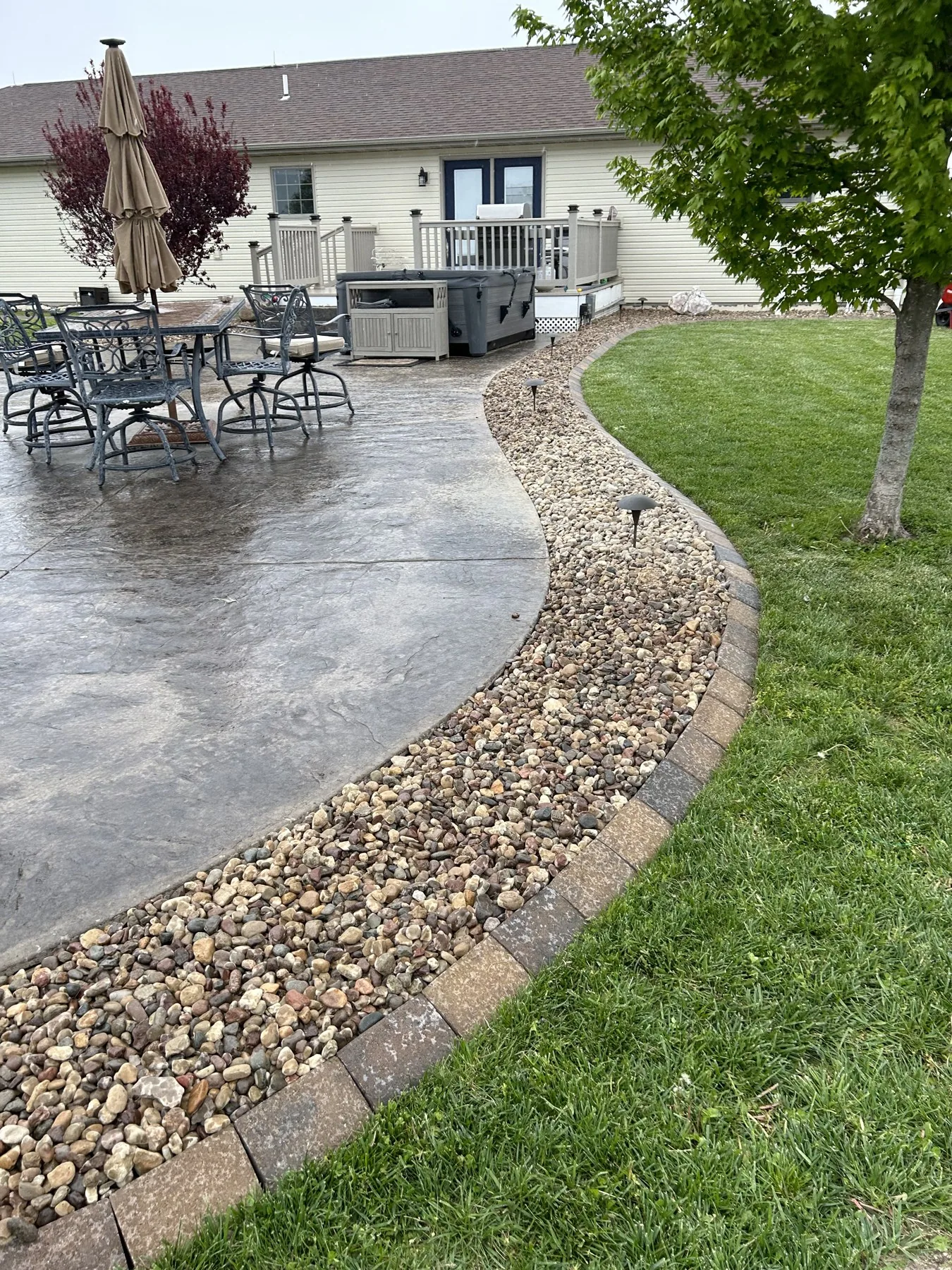 Paver walkway curving through a landscaped lawn