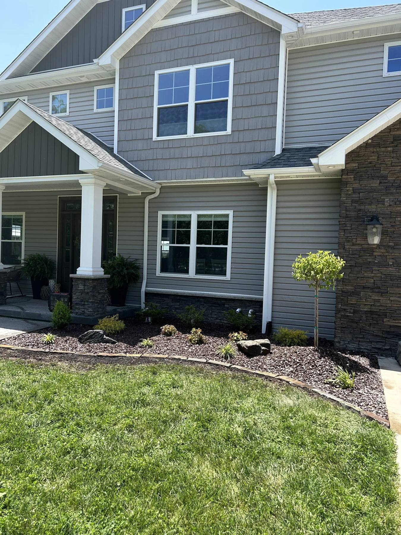 Two-story home with tidy mulch beds and a healthy lawn