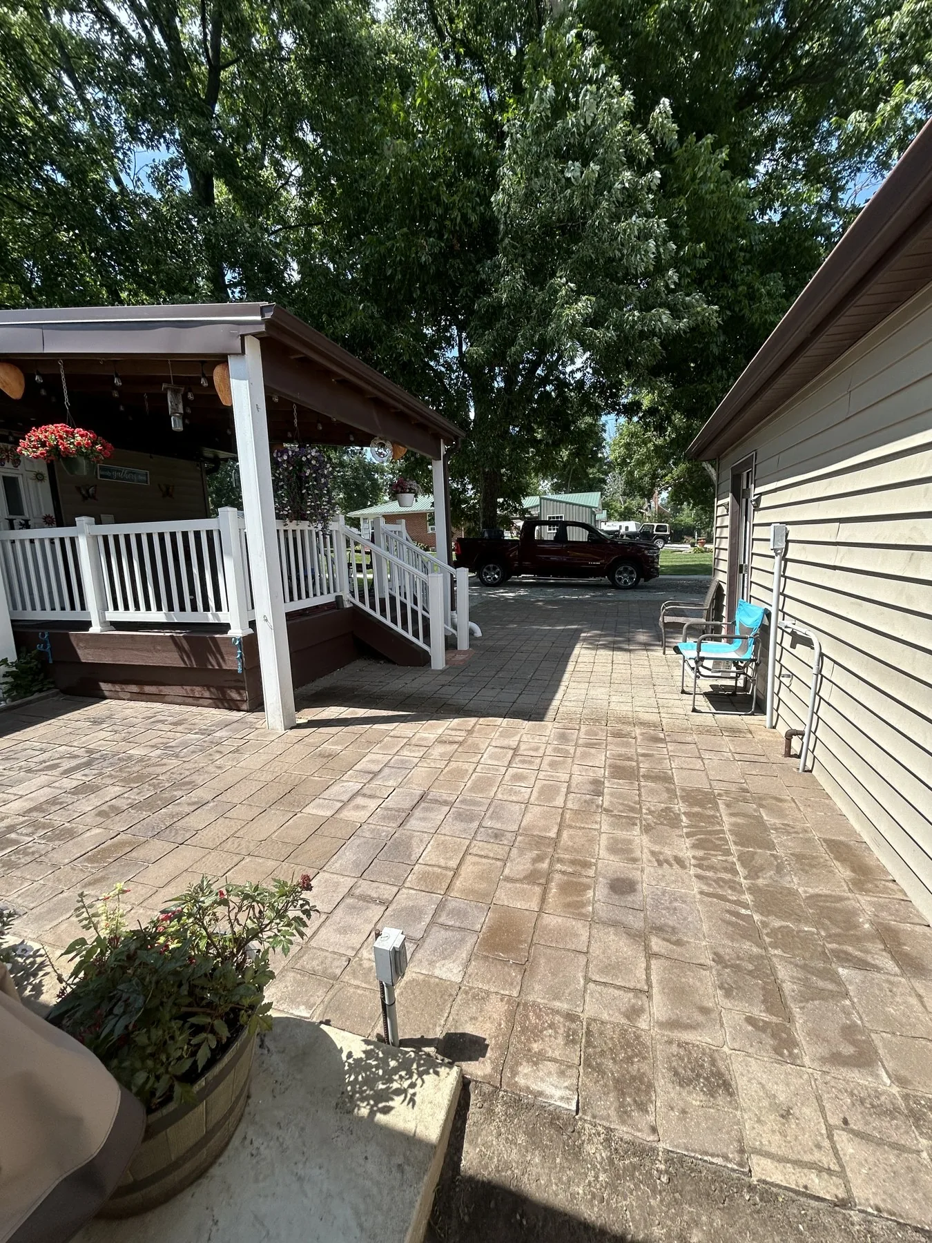 Large paver patio with a covered porch and outdoor seating